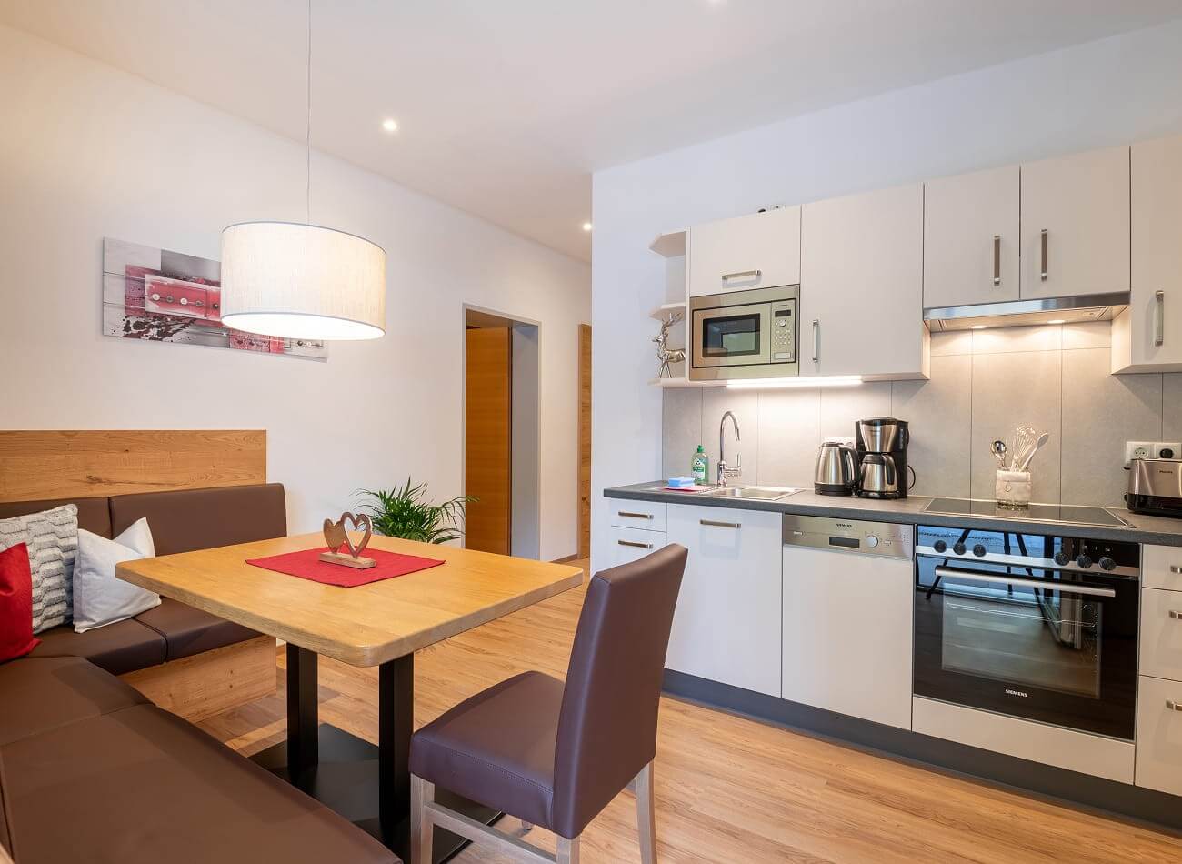 Moderne Wohnk&uuml;che mit Essbereich im Familienappartement A1 der Appartements Schattauer