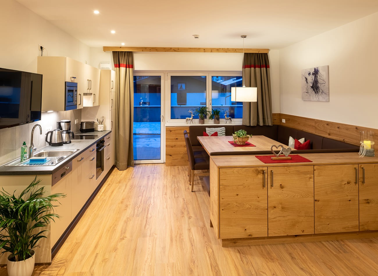Moderne Wohnk&uuml;che mit offenem Essbereich und Balkonzugang im Deluxe Appartement A3