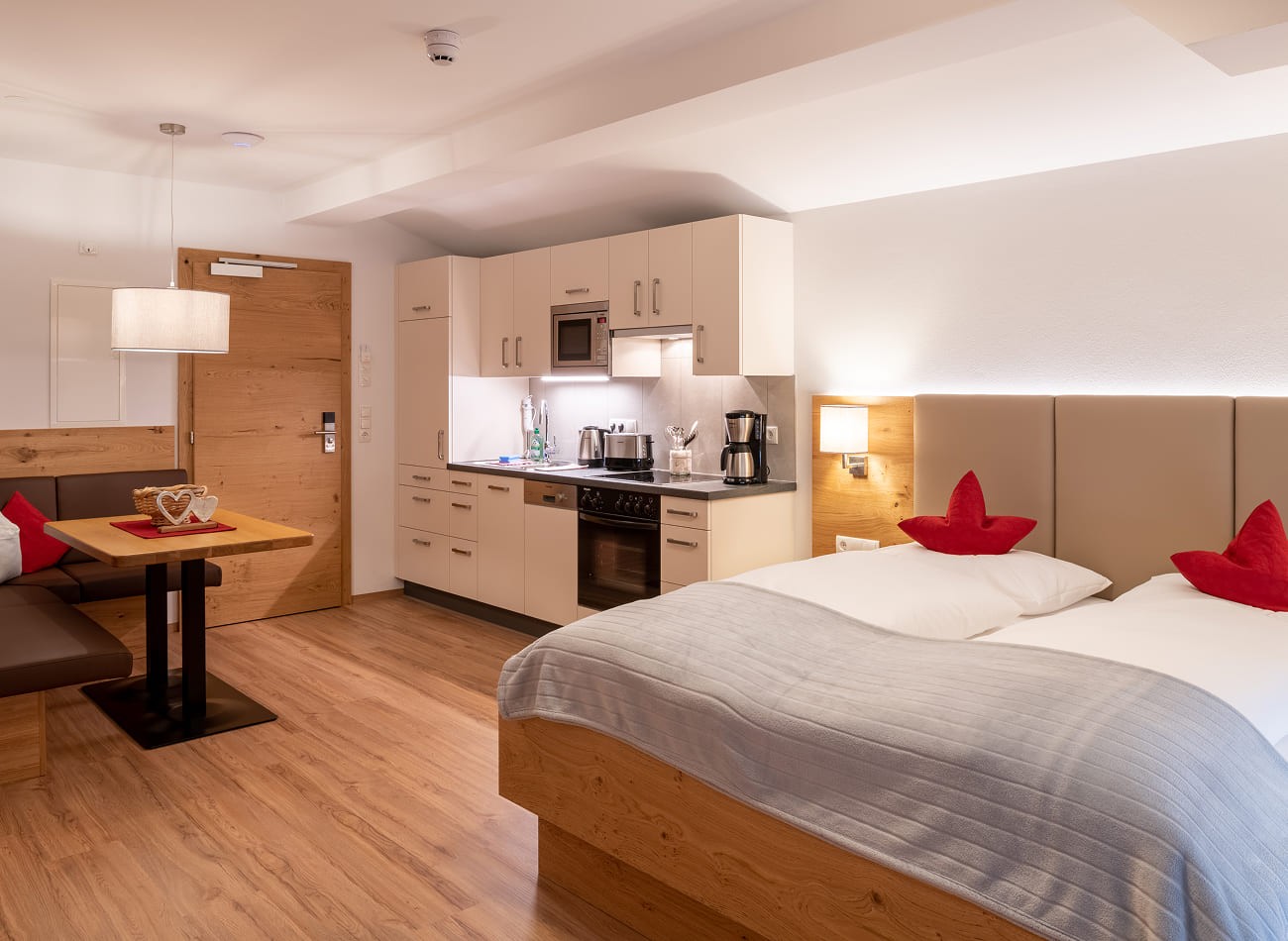 Gem&uuml;tlicher Schlafbereich mit Doppelbett und K&uuml;chenzeile im Studio D1 der Appartements Schattauer