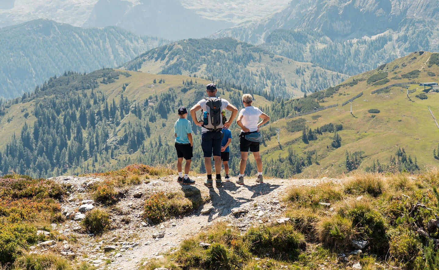Familie beim Wandern mit Panoramablick auf die Berglandschaft von Wagrain © Wagrain-Kleinarl Tourismus/ Miriam Lottes