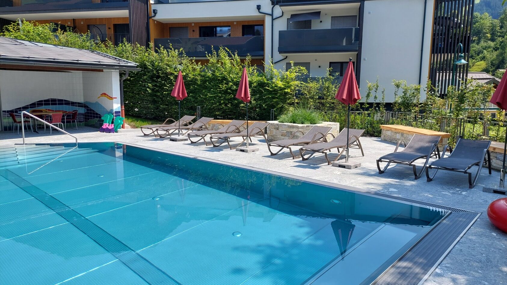Entspannte Urlaubsmomente auf den Sonnenliegen am beheizten Pool der Appartements Schattauer