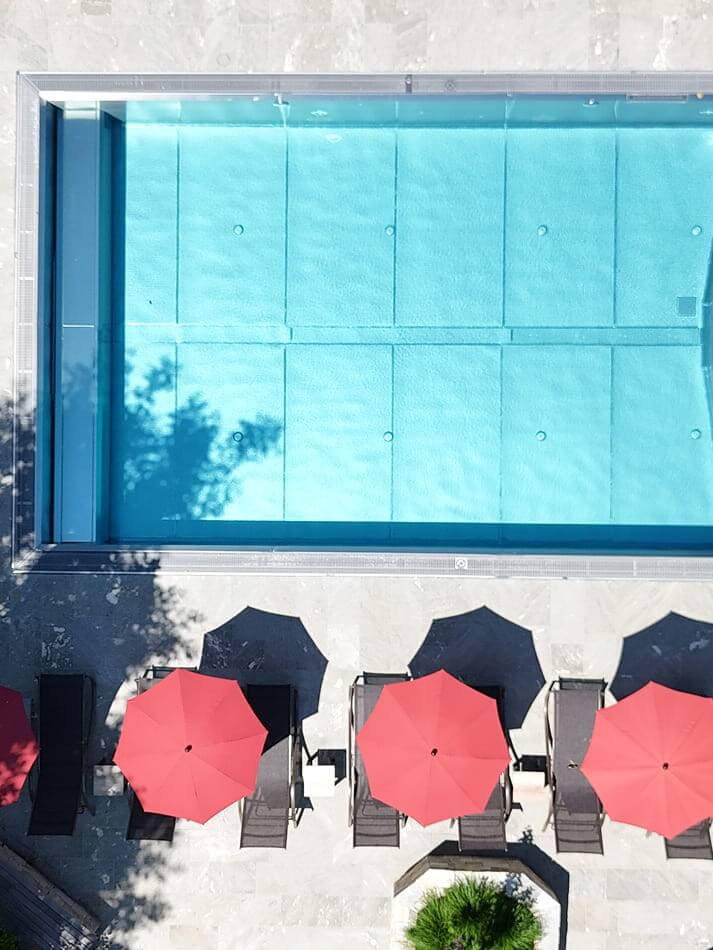 Outdoorpool mit Sonnenliegen und Sonnenschirmen der Appartements Schattauer