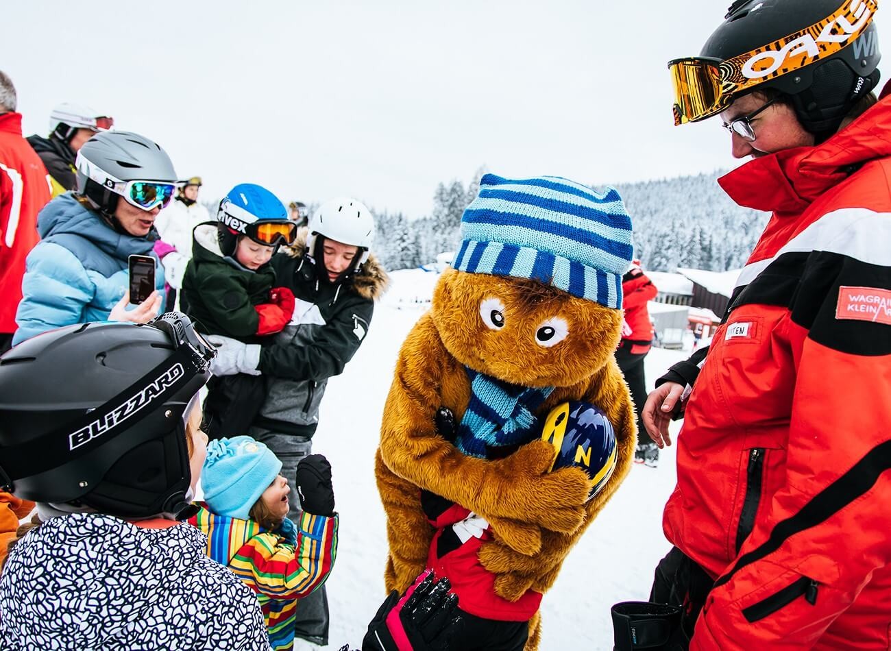 Fr&ouml;hliche Begegnung mit Wagraini in der Winterwelt &ndash; ein Highlight f&uuml;r Familien im Winterurlaub &copy; Wagrain-Kleinarl Tourismus